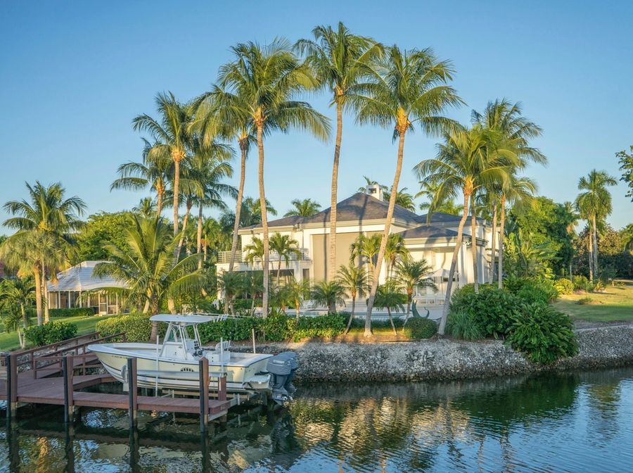 Waterfront home with palms and a private dock