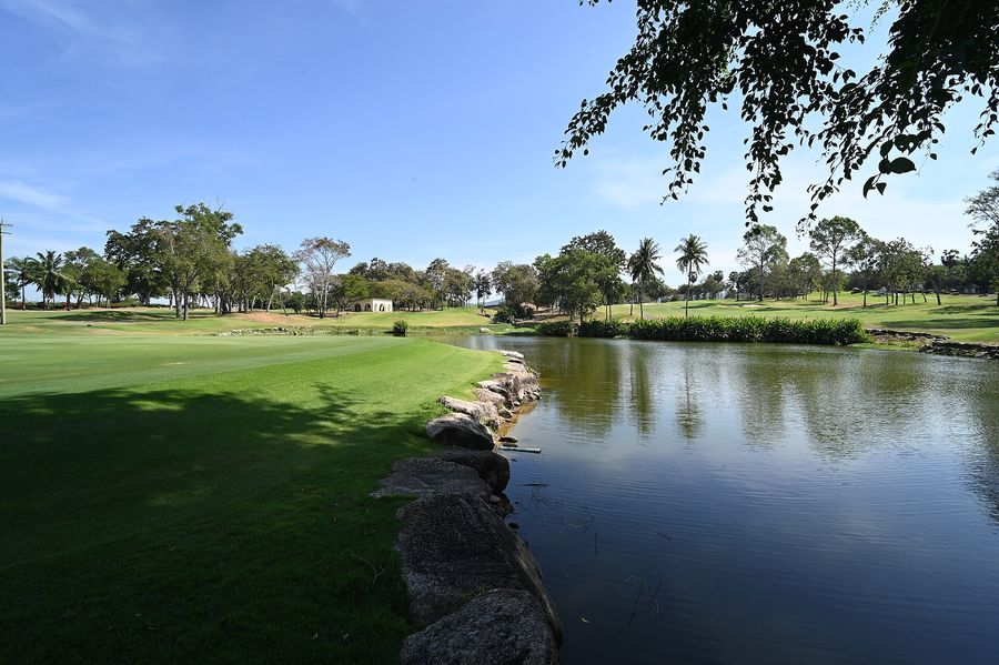 Water hazard beside a sunlit fairway