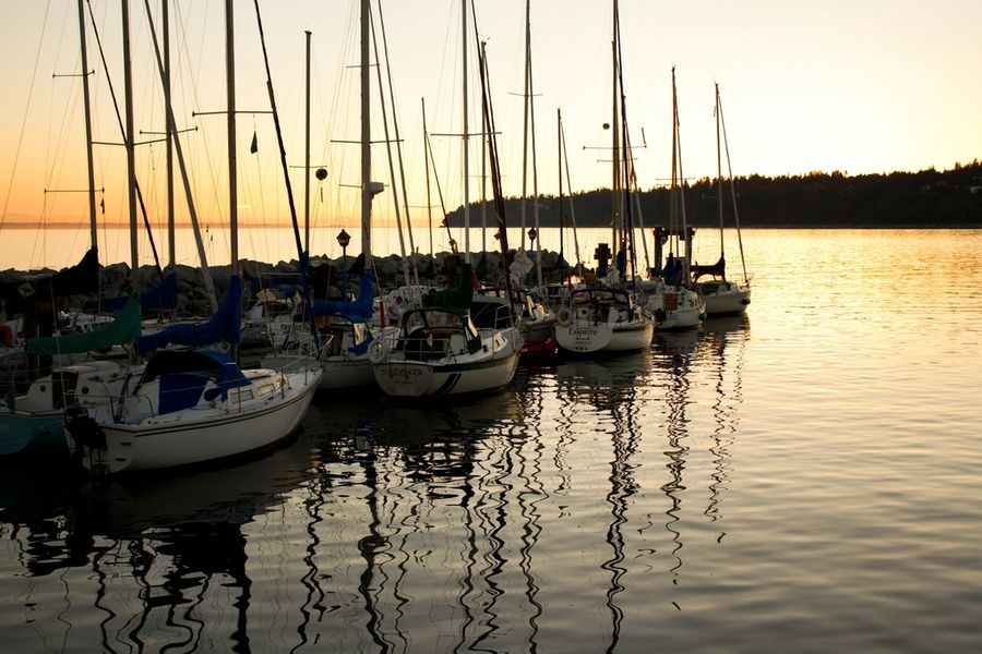 Sailboats moored at sunset